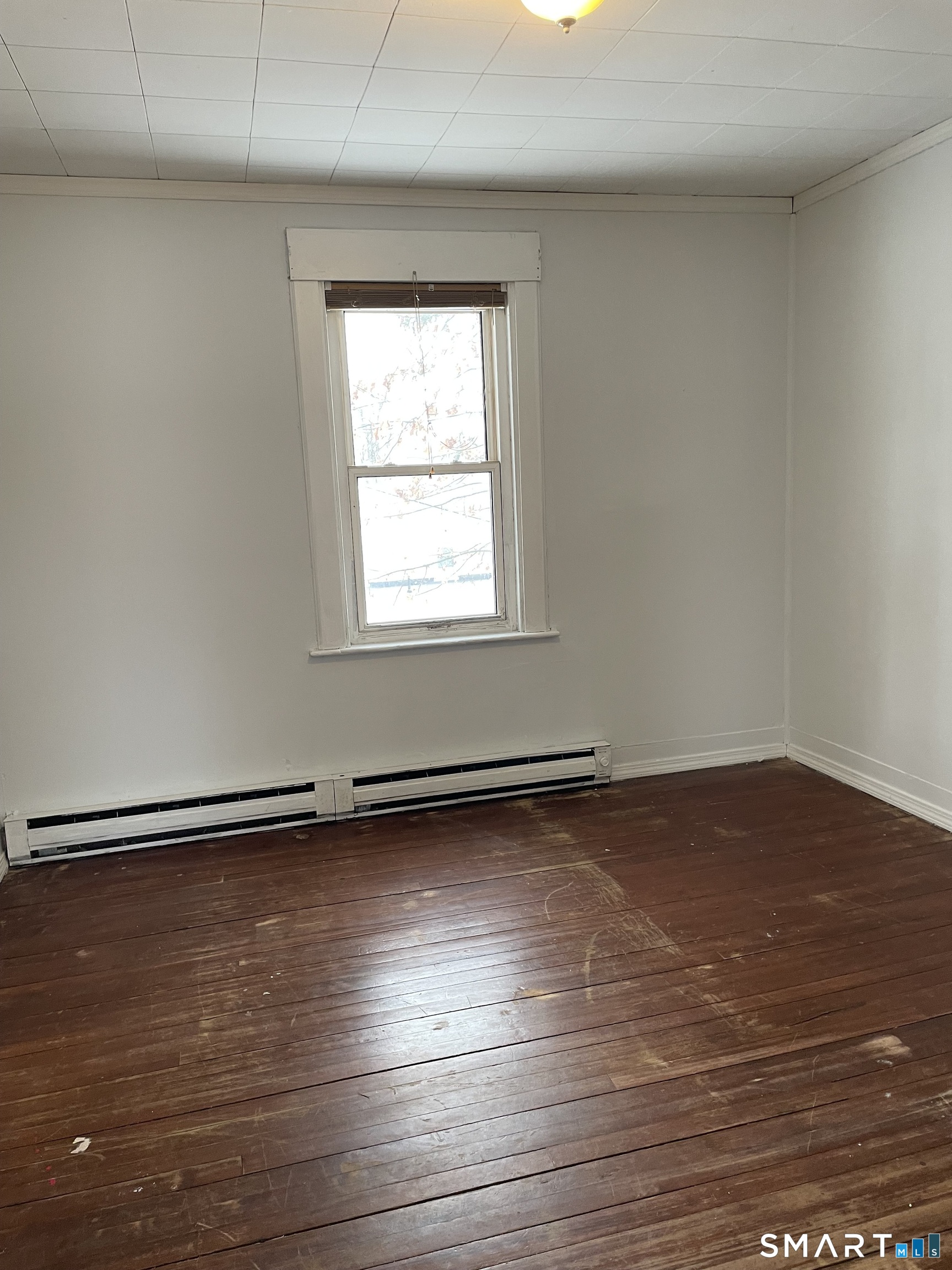 184 Meriden Road Waterbury, CT 06705 - Photo 4 of 14 an empty room with wooden floor and windows