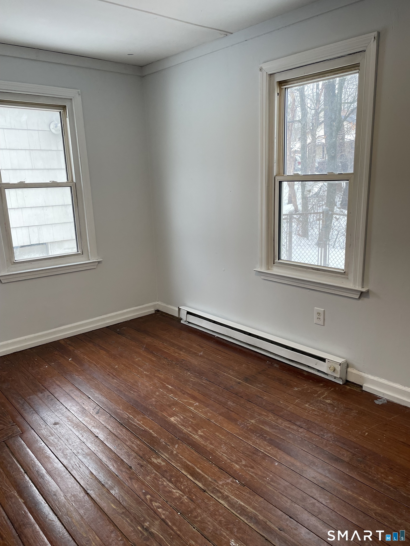 184 Meriden Road Waterbury, CT 06705 - Photo 8 of 14 an empty room with wooden floor and windows