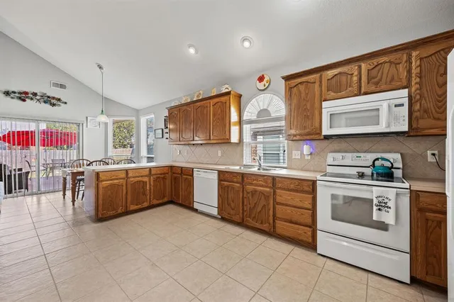 a kitchen with stainless steel appliances granite countertop a stove sink and cabinets