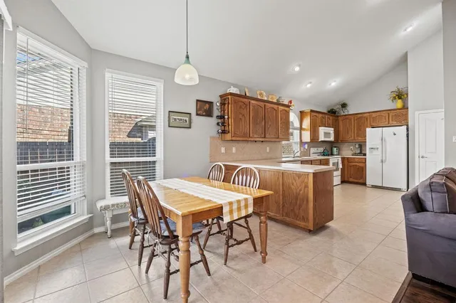 a kitchen with kitchen island a dining table and chairs