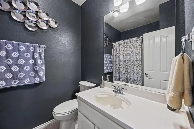 a bathroom with a sink vanity mirror and toilet