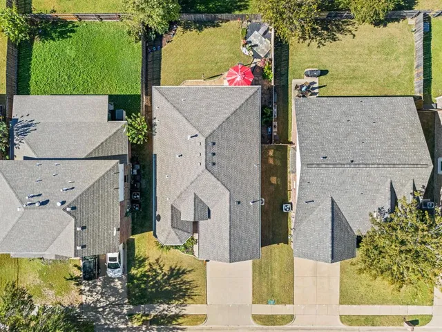an aerial view of a house with a yard and large tree
