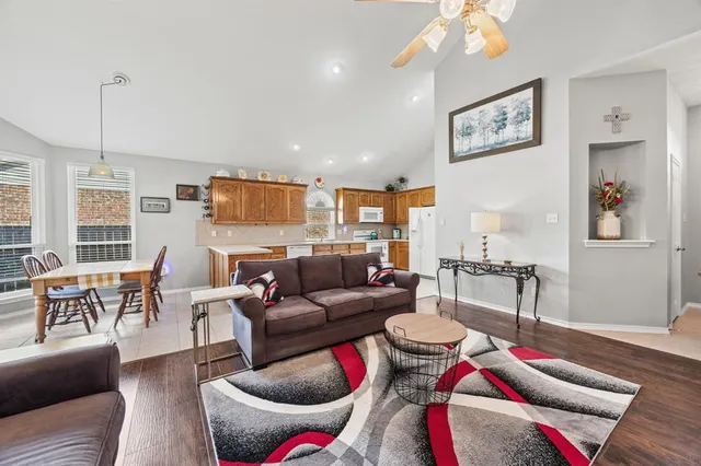 a living room with furniture and a dining table with rug