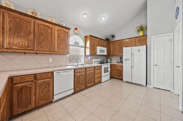 a kitchen with a refrigerator sink and cabinets