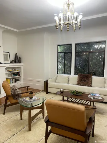 a living room with furniture chandelier and a window