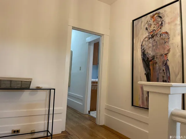 a view of a hallway with wooden floor and closet