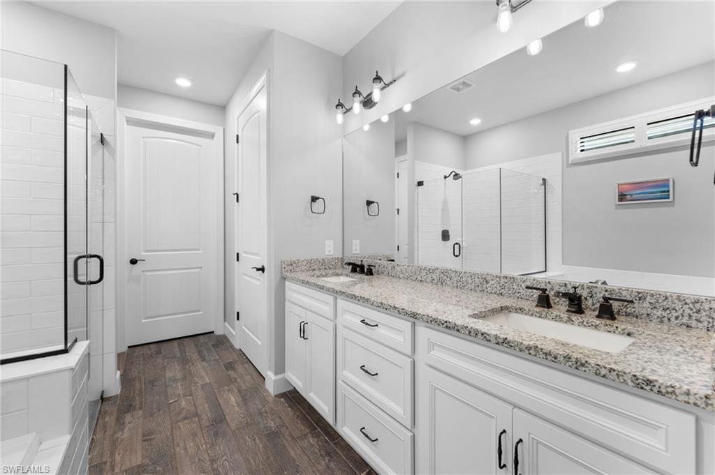 14240 Moonlit Way Estero, FL 33928 - Photo 13 of 50 a spacious bathroom with a granite countertop sink a mirror a shower and a bathtub