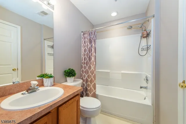 a bathroom with a sink vanity mirror and toilet