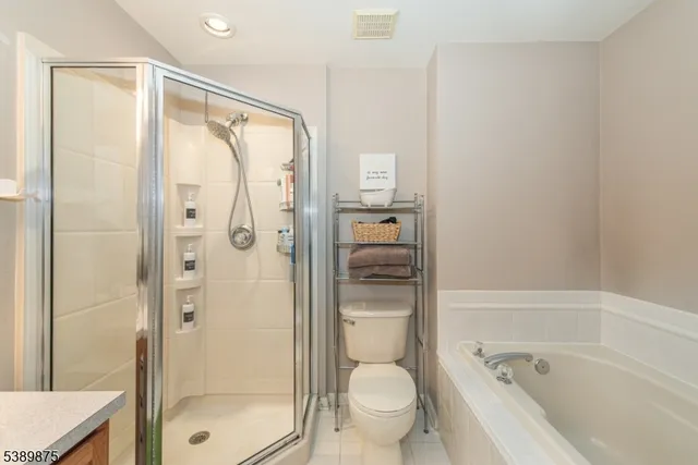 a bathroom with a granite countertop bathtub shower and toilet