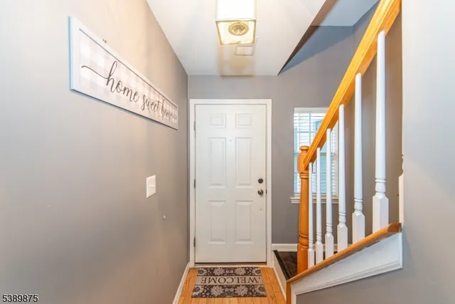 a view of a hallway with wooden door and stairs