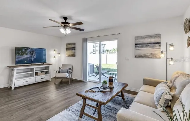 a living room with furniture a flat screen tv and a window