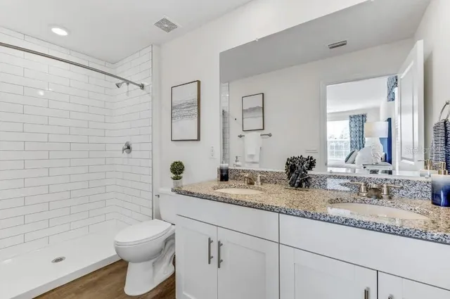 a bathroom with a granite countertop sink a toilet and shower