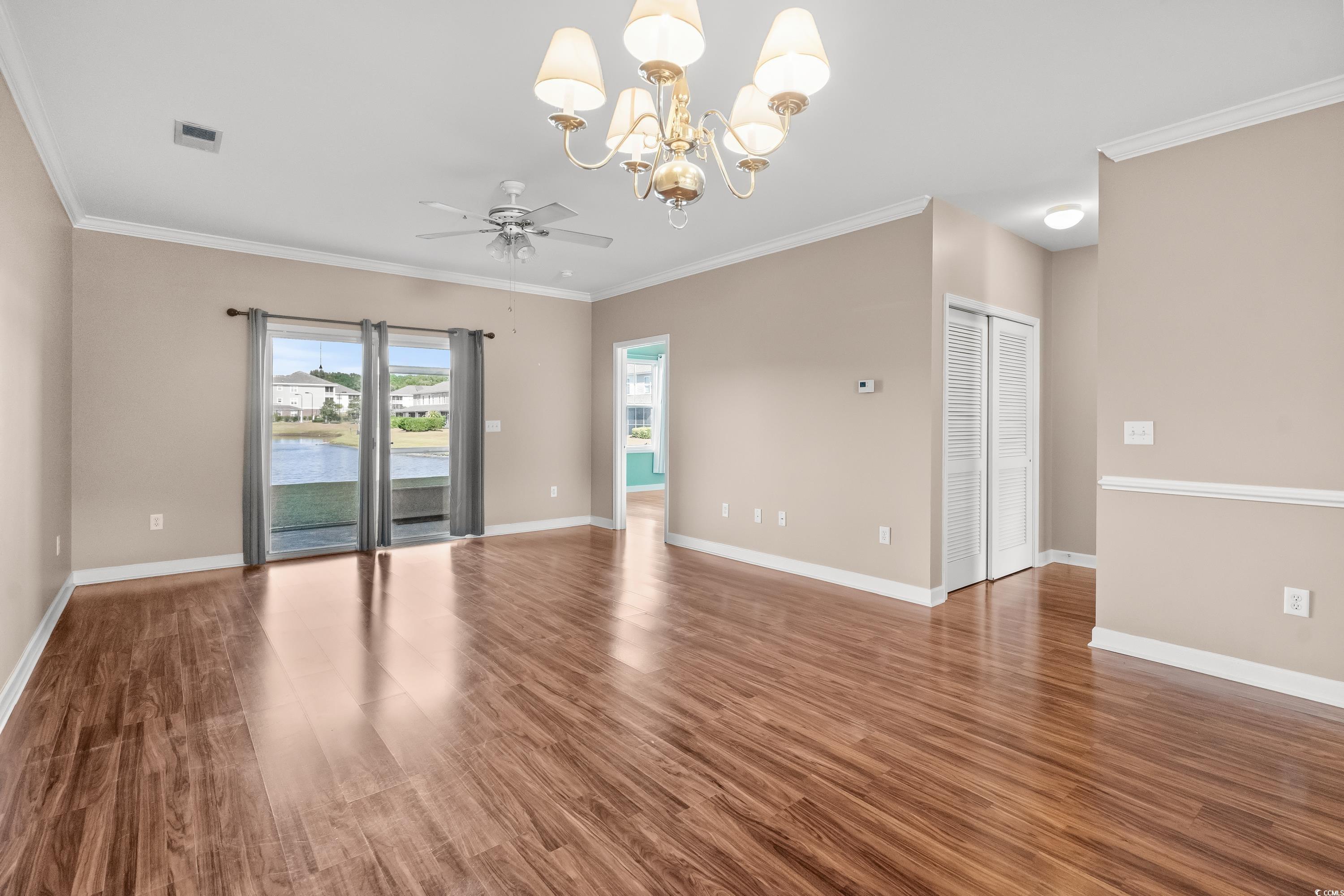 336 Kiskadee Loop, Unit B Conway, SC 29526 - Photo 13 of 40 Empty room featuring ornamental molding, ceiling fan with notable chandelier, and dark hardwood / wood-style flooring