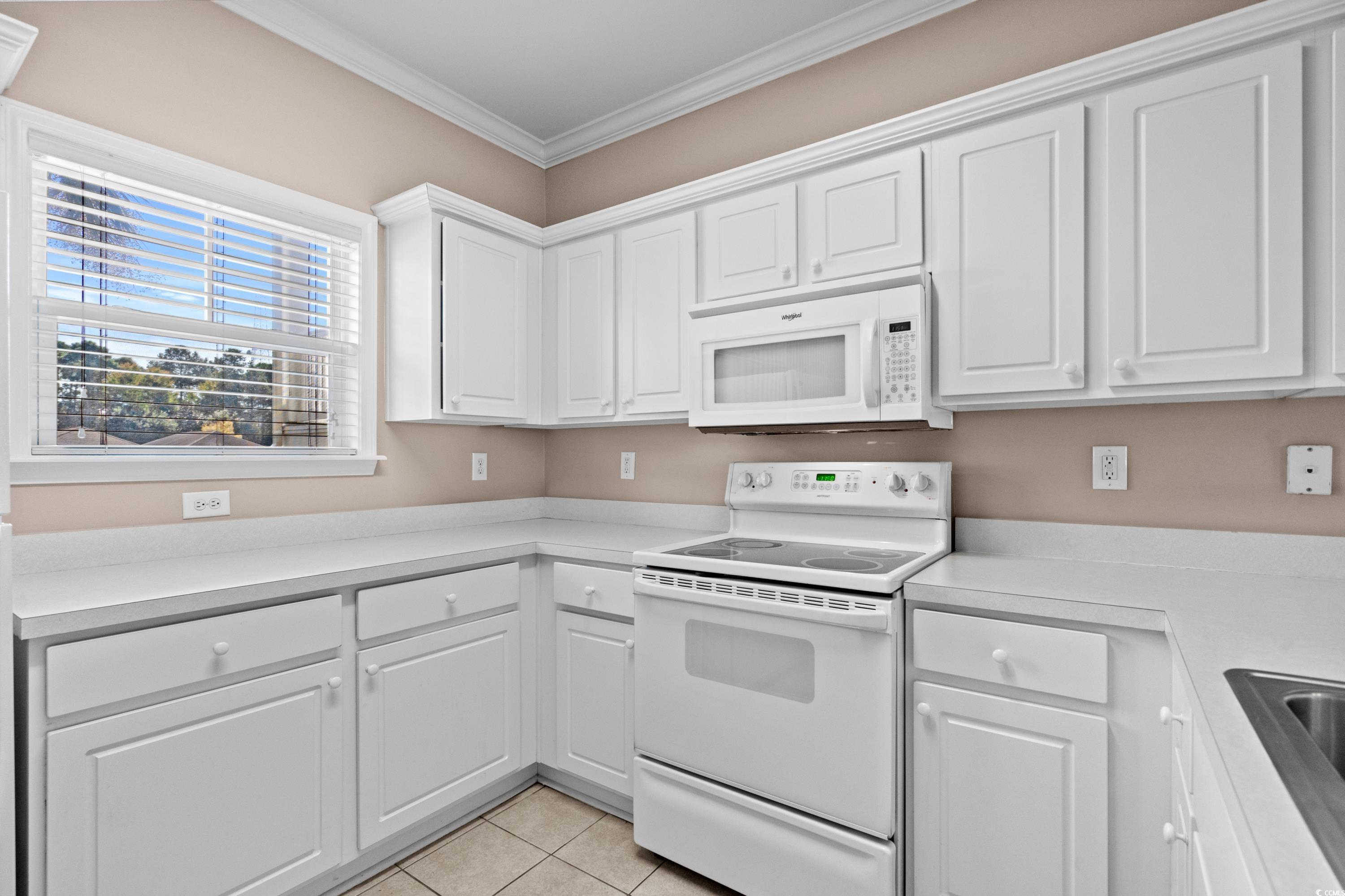 336 Kiskadee Loop, Unit B Conway, SC 29526 - Photo 17 of 40 Kitchen featuring white appliances, crown molding, white cabinetry, and light tile patterned floors