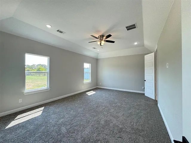an empty room with windows and a ceiling fan