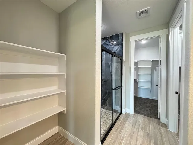 a view of a hallway with wooden floor and closet