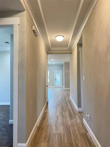 a view of a hallway with wooden floor and staircase