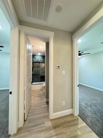 a view of a hallway with wooden floor and staircase