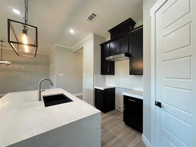 a kitchen with stainless steel appliances granite countertop a refrigerator a stove a sink and a microwave