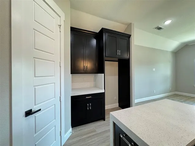a room with a refrigerator and cabinets