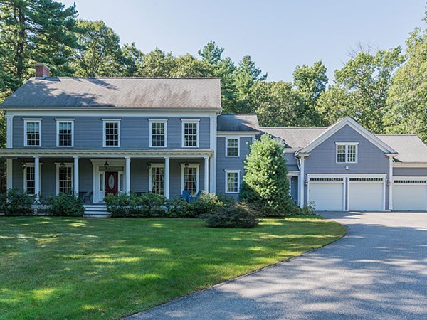 a front view of a house with a yard and trees