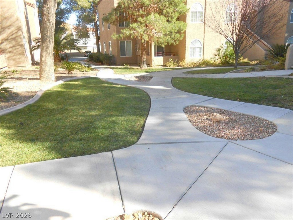 9325 West Desert Inn Road, Unit 132 Las Vegas, NV 89117 - Photo 24 of 36 Meandering pathways connect verdant green spaces with mature trees, inviting strolls through the community.