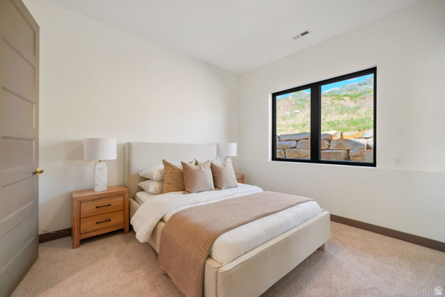 10646 North Reflection Ridge Hideout, UT 84036 - Photo 15 of 43 Carpeted bedroom featuring a large window with black trim, a paneled interior door, and light-toned walls