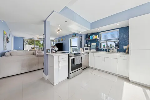 a kitchen with white cabinets and white appliances