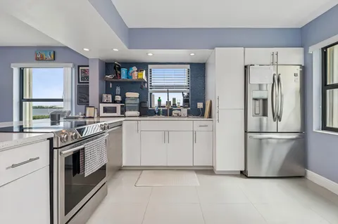a kitchen with white cabinets and white stainless steel appliances