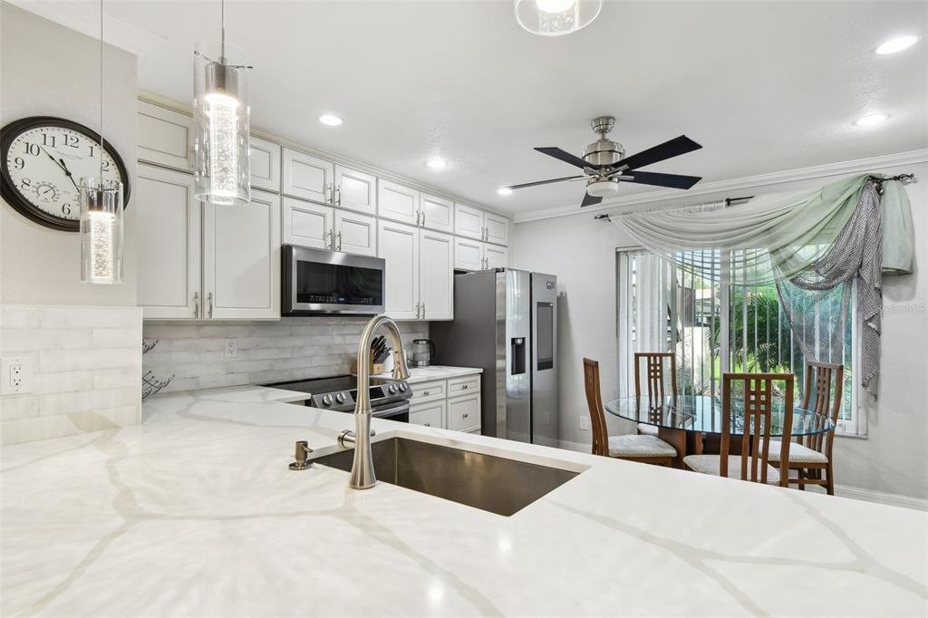1801 East Lake Road South, Unit 3A Palm Harbor, FL 34685 - Photo 11 of 56 a kitchen with stainless steel appliances granite countertop a sink a stove and a refrigerator