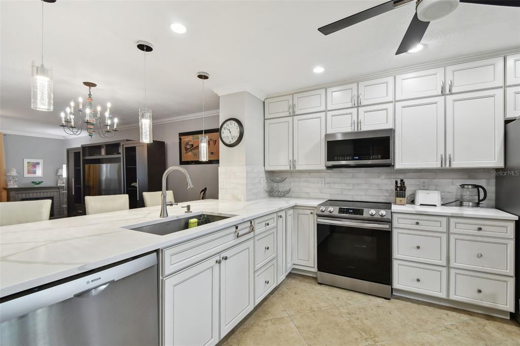 1801 East Lake Road South, Unit 3A Palm Harbor, FL 34685 - Photo 13 of 56 a kitchen with a sink stove and microwave