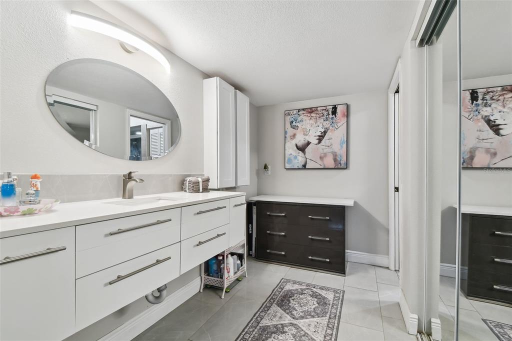 1801 East Lake Road South, Unit 3A Palm Harbor, FL 34685 - Photo 20 of 56 a spacious bathroom with a double vanity sink and a mirror