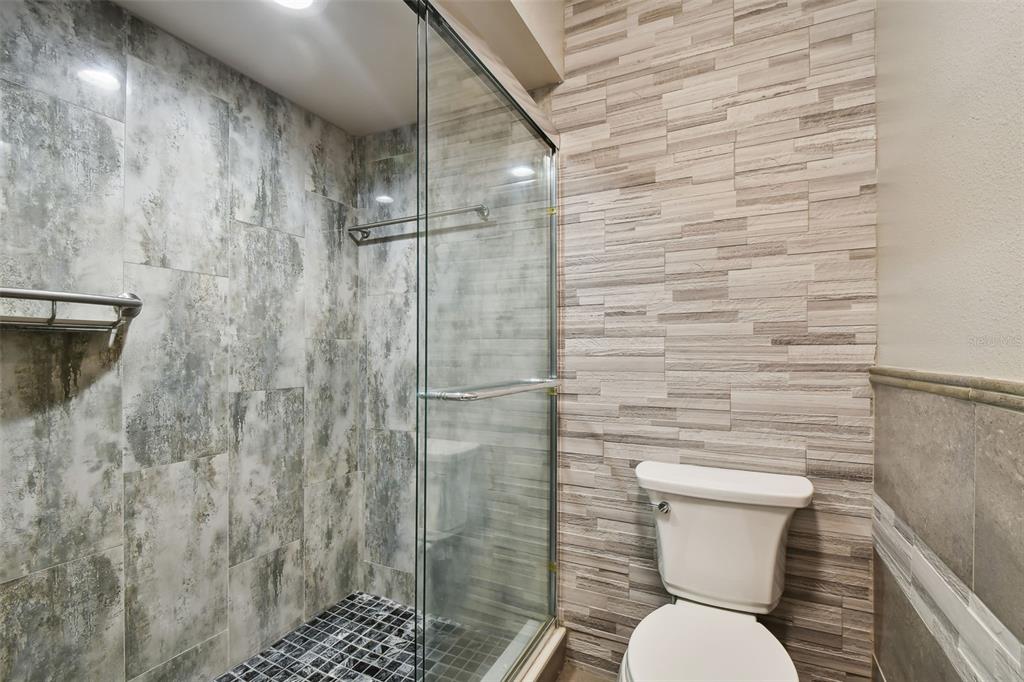 1801 East Lake Road South, Unit 3A Palm Harbor, FL 34685 - Photo 24 of 56 a bathroom with a toilet and a shower