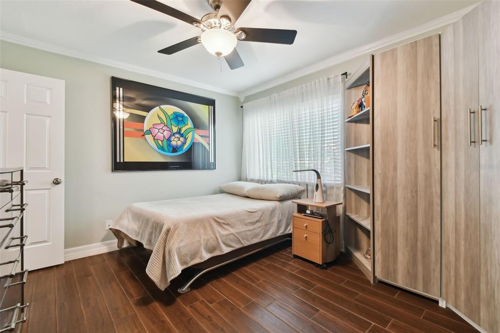 1801 East Lake Road South, Unit 3A Palm Harbor, FL 34685 - Photo 28 of 56 a bedroom with a bed and a painting on the wall