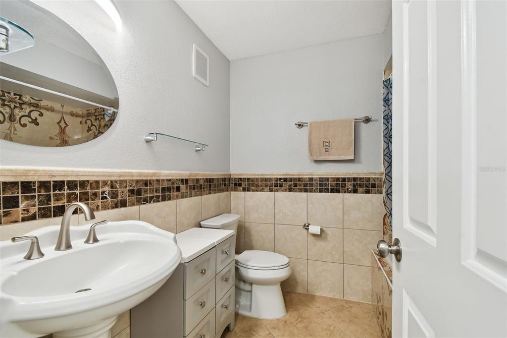 1801 East Lake Road South, Unit 3A Palm Harbor, FL 34685 - Photo 29 of 56 a bathroom with a toilet sink and mirror