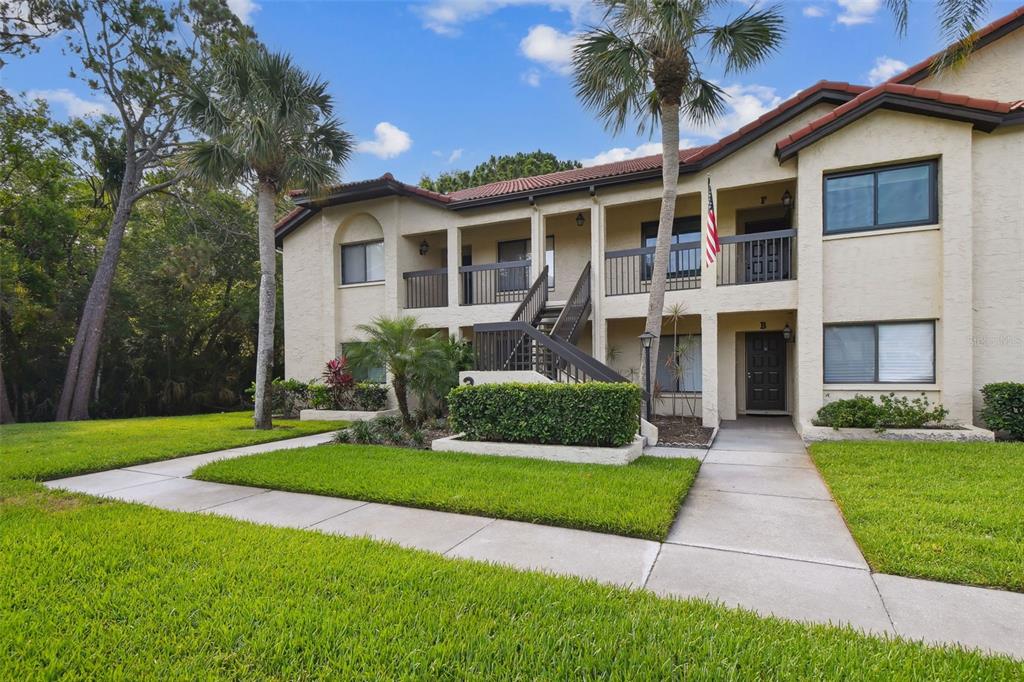 1801 East Lake Road South, Unit 3A Palm Harbor, FL 34685 - Photo 37 of 56 a front view of a house with a yard and garage