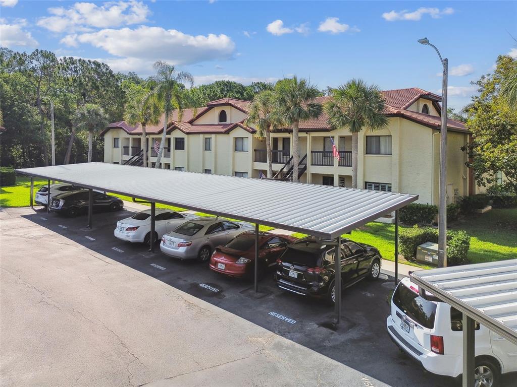 1801 East Lake Road South, Unit 3A Palm Harbor, FL 34685 - Photo 43 of 56 a view of a patio with table and chairs with wooden floor and fence
