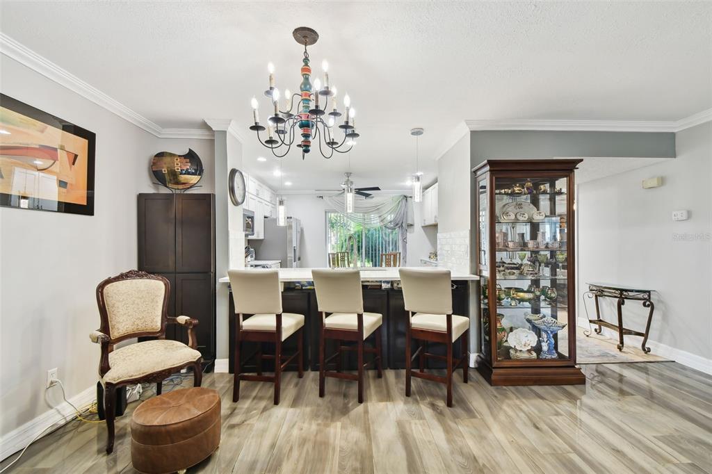 1801 East Lake Road South, Unit 3A Palm Harbor, FL 34685 - Photo 10 of 56 a view of a dining room with furniture window and wooden floor