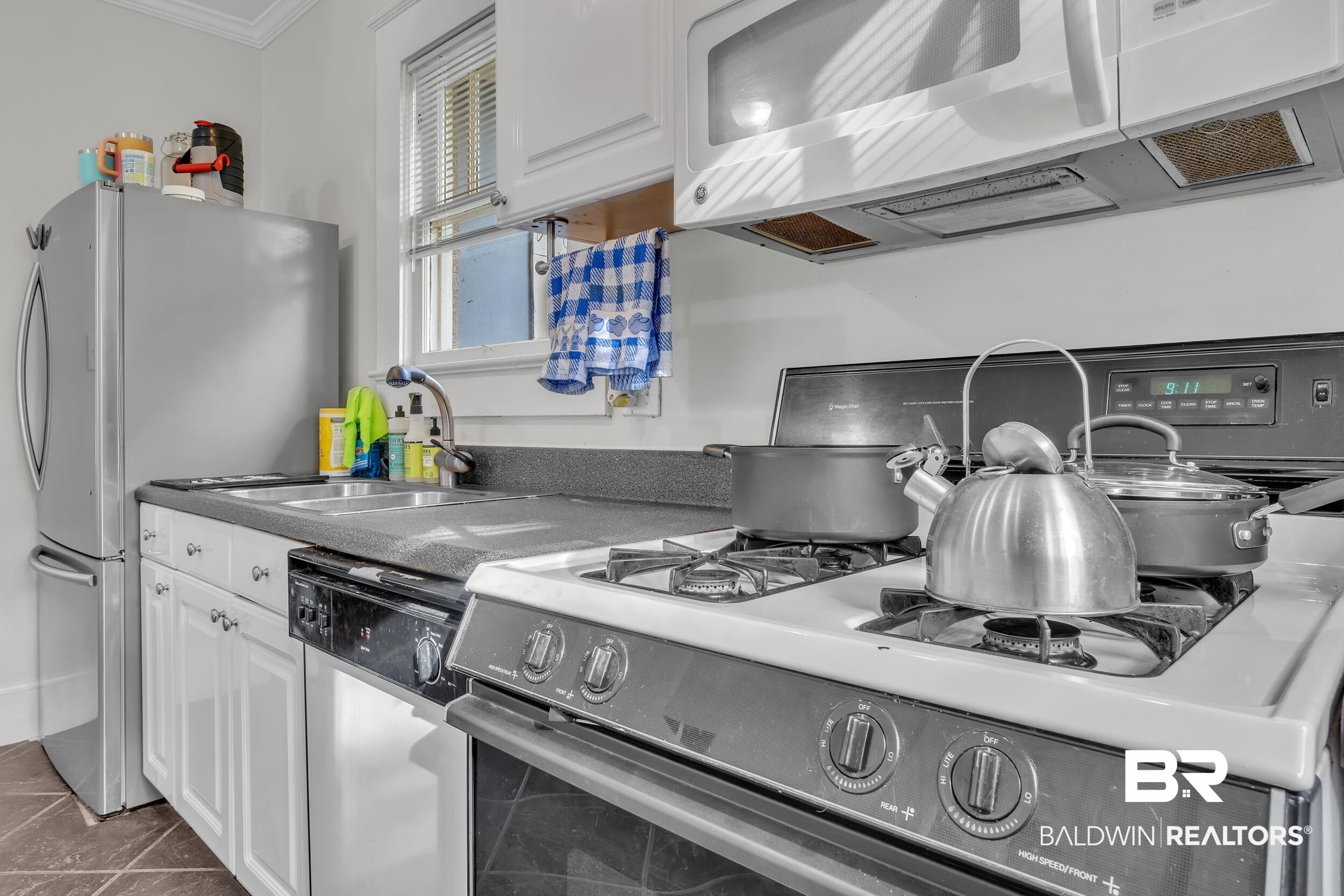 55 Mohawk Street Mobile, AL 36606 - Photo 26 of 28 Kitchen with ornamental molding, appliances with stainless steel finishes, white cabinetry, and a sink