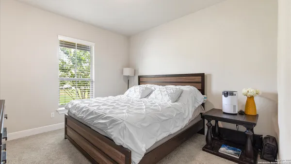 a bed sitting in a bedroom next to a window