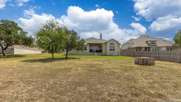 a house view with swimming pool and trees in the background