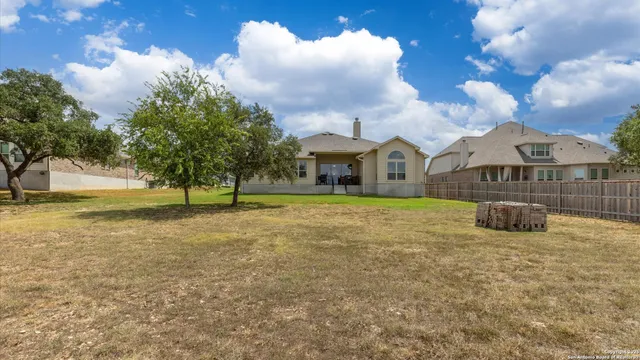 a house view with swimming pool and trees in the background