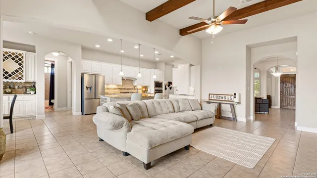 a living room with furniture kitchen view and a chandelier