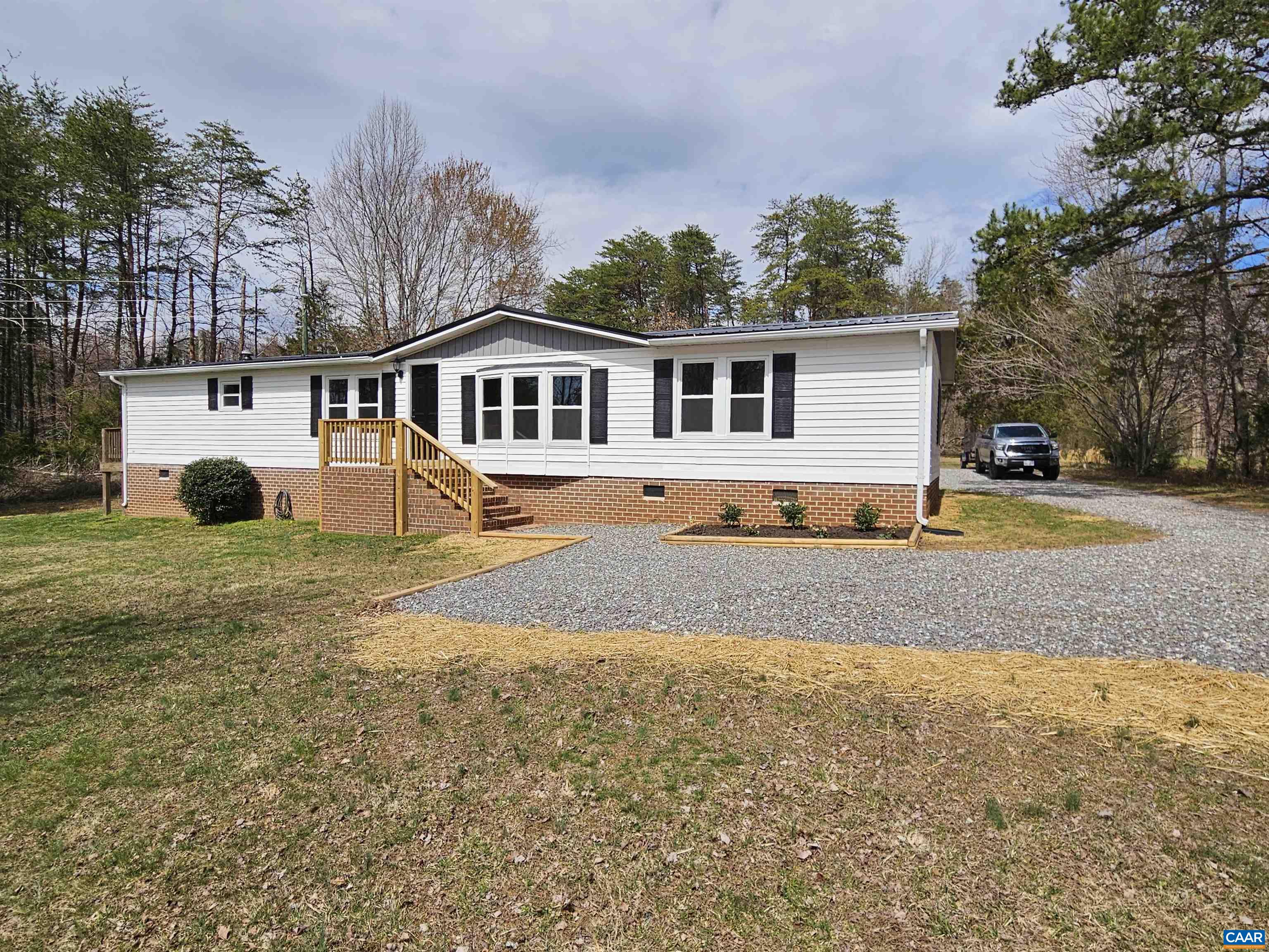 a front view of a house with a yard and trees