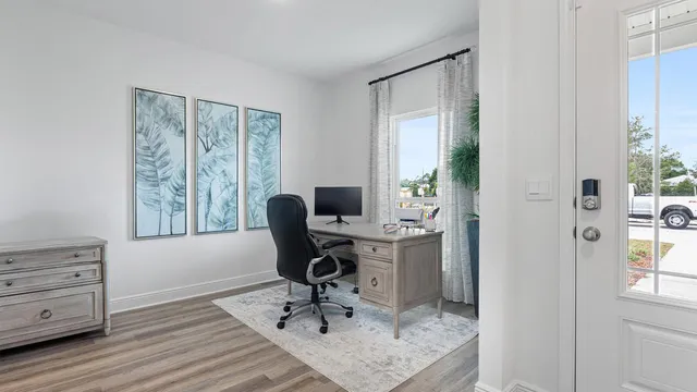 a view of a workspace with furniture and a window