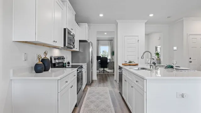 a kitchen with kitchen island granite countertop a sink cabinets and wooden floor