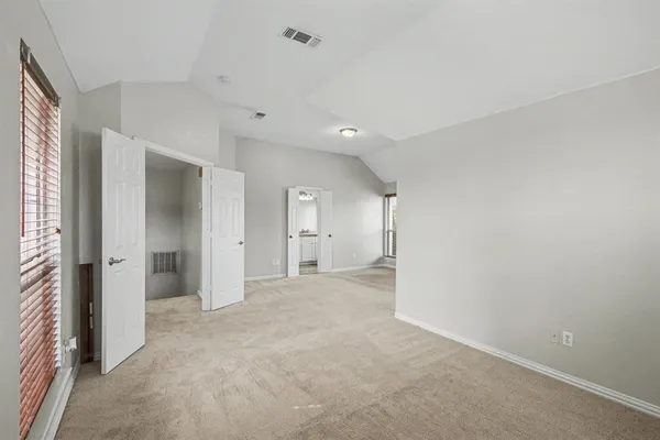 an empty room with a cabinet and a window