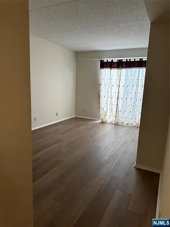 an empty room with wooden floor and a window