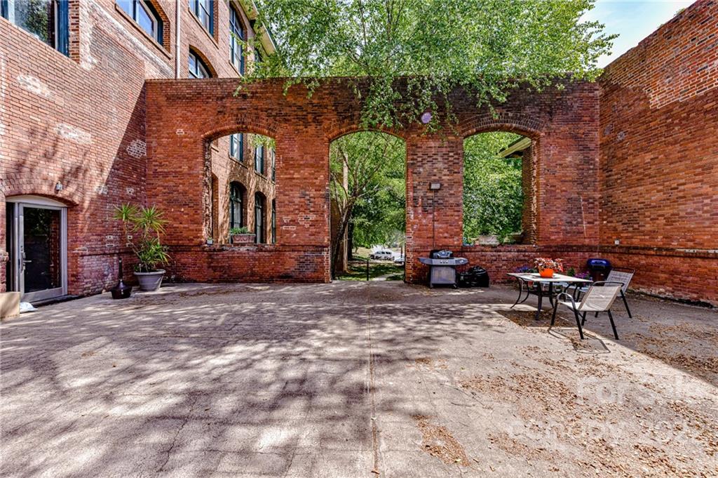 201 South Hoskins Road, Unit 106 Charlotte, NC 28208 - Photo 14 of 18 a brick building with a bench in front of it