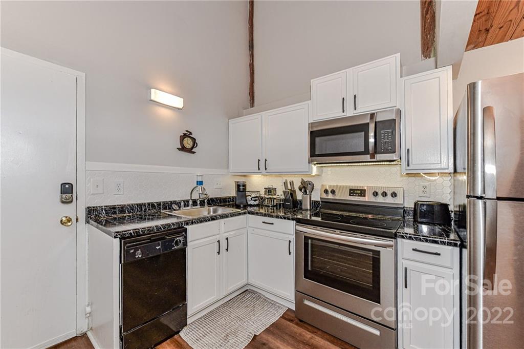 201 South Hoskins Road, Unit 106 Charlotte, NC 28208 - Photo 2 of 18 a kitchen with a stove a sink and a microwave